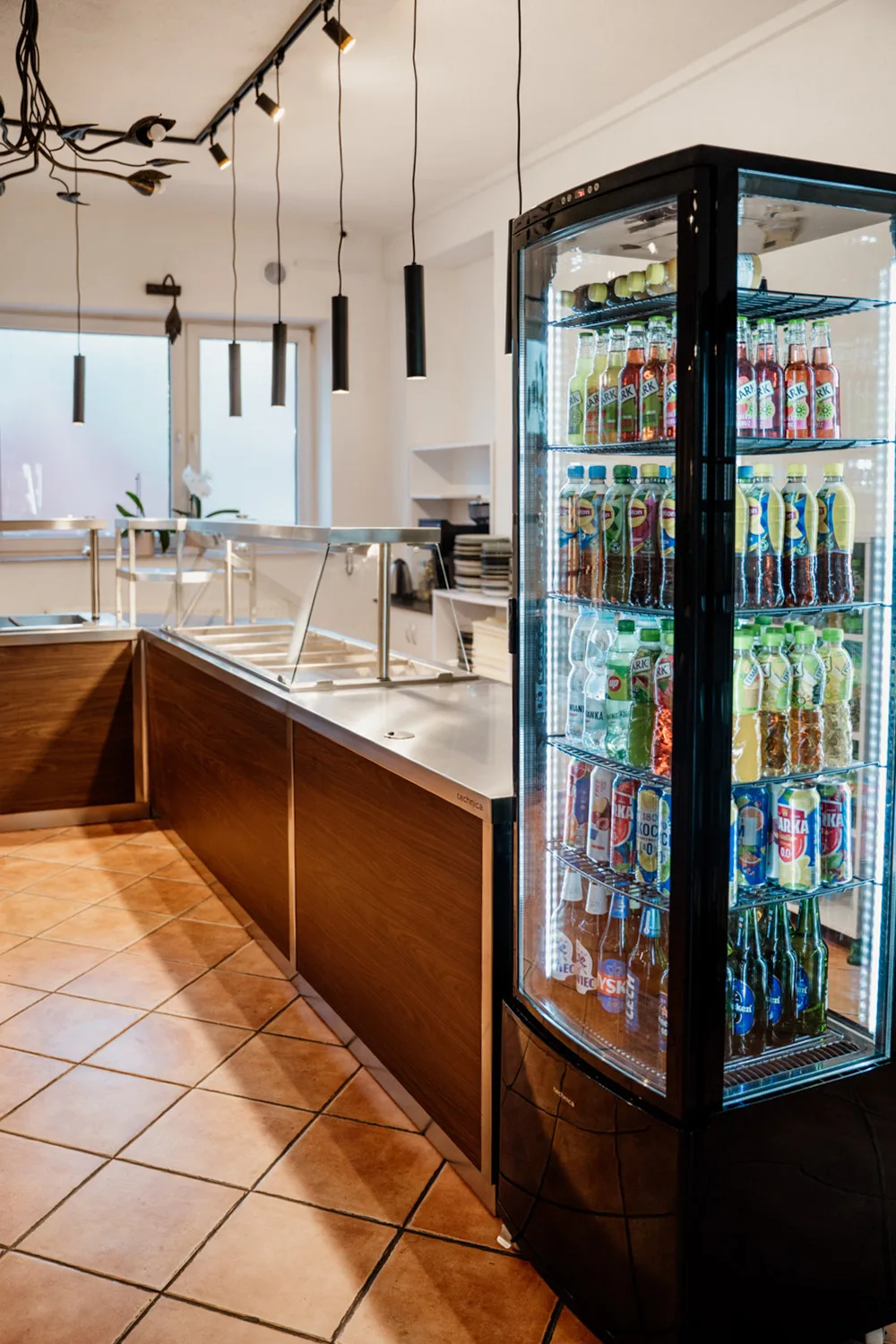 Stalowy stół gastronomiczny z nadstawką i szafką chłodniczą Technica.