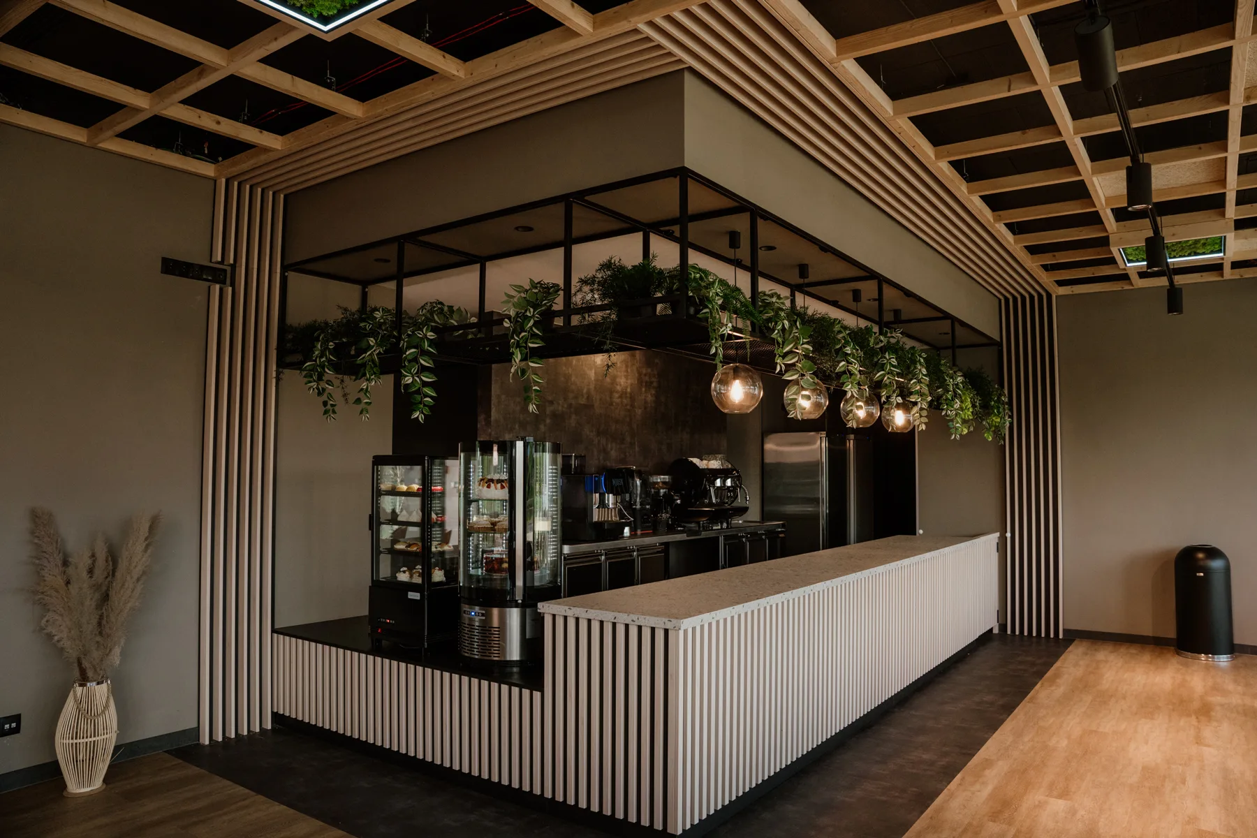 Widok na barek, witryny chłodnicze na desery i ciasta w nowoczesnej kawiarni – elegancka ekspozycja słodkości na ladzie barowej.