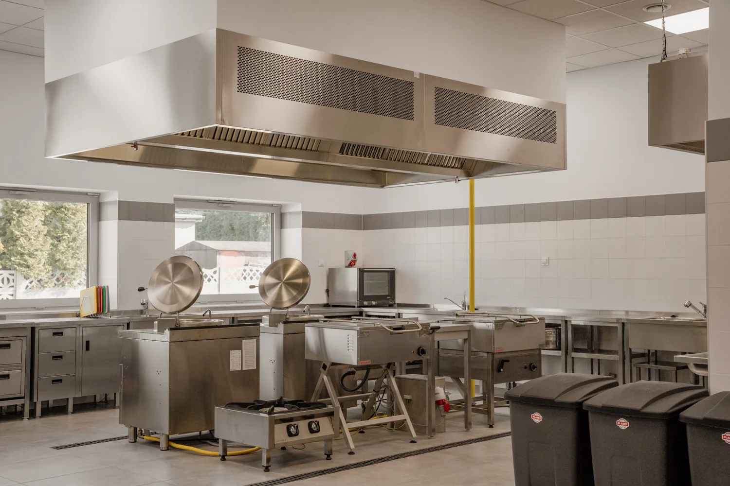 Wnętrze profesjonalnej kuchni nierdzewnej w jednostce budżetowej.