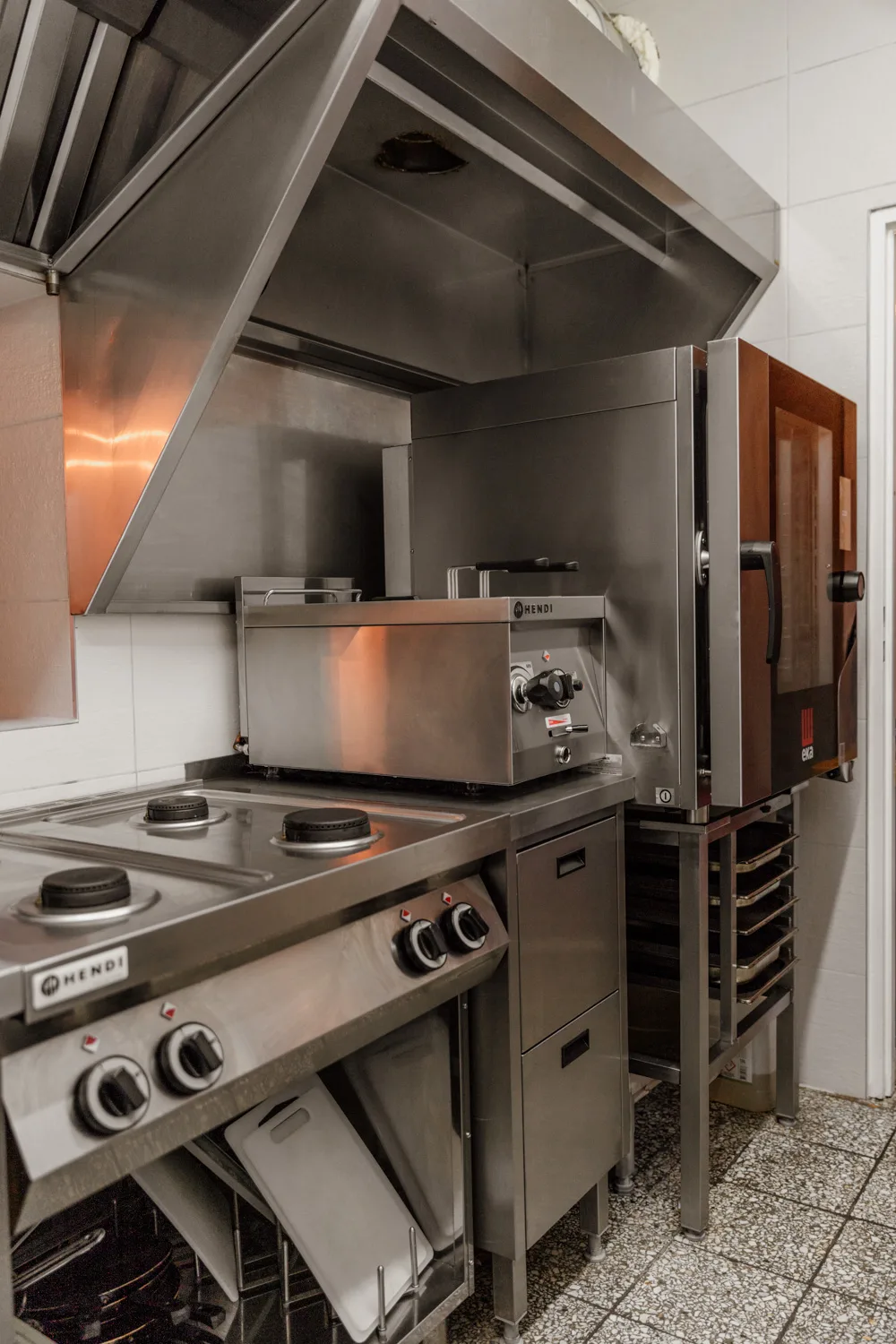 Profesjonalna kuchnia gastronomiczna z linią grzewczą Hendi, piecem konwekcyjno-parowym oraz okapem ze stali nierdzewnej.