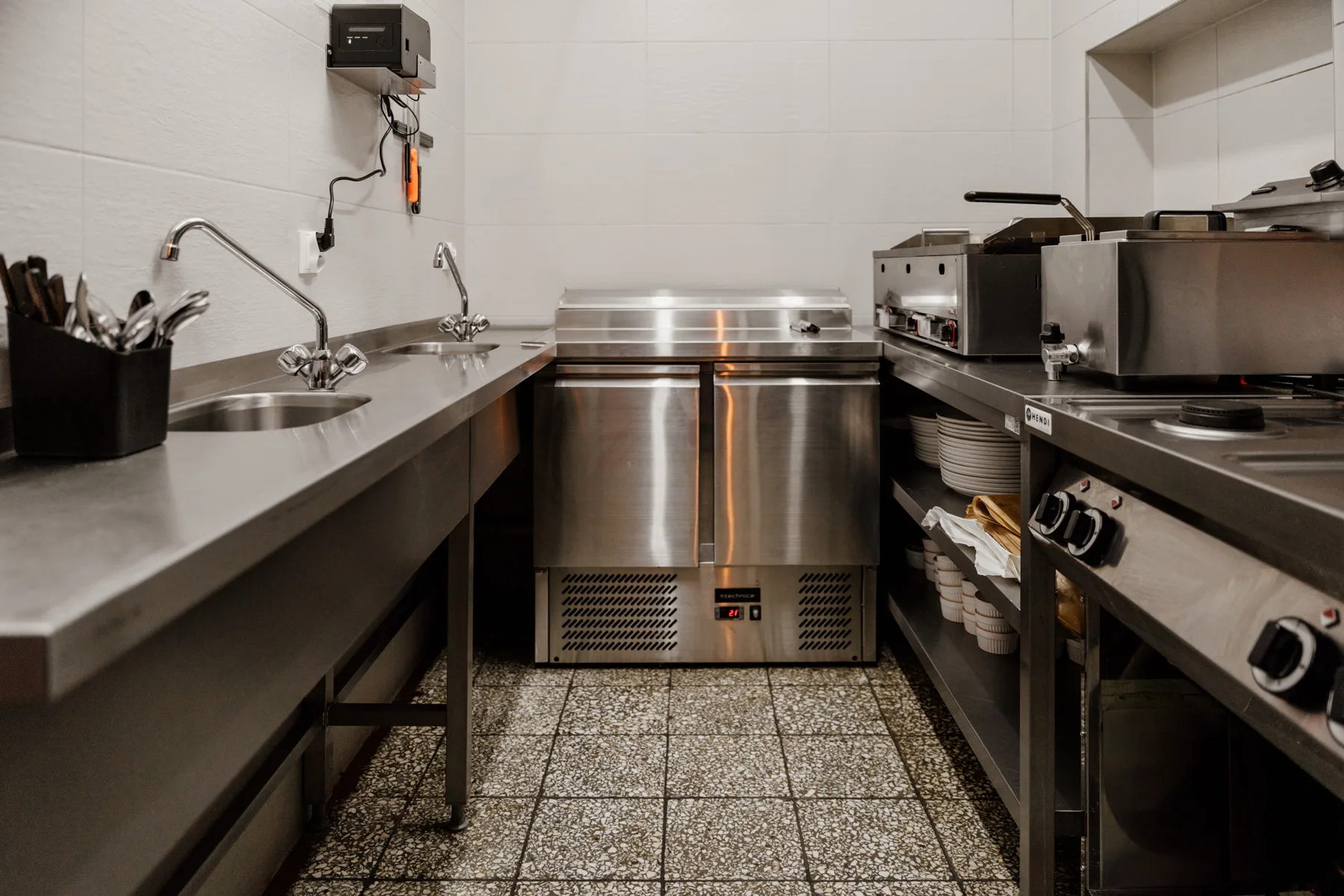 Nowoczesna kuchnia gastronomiczna ze stali nierdzewnej, wyposażona w profesjonalne urządzenia.