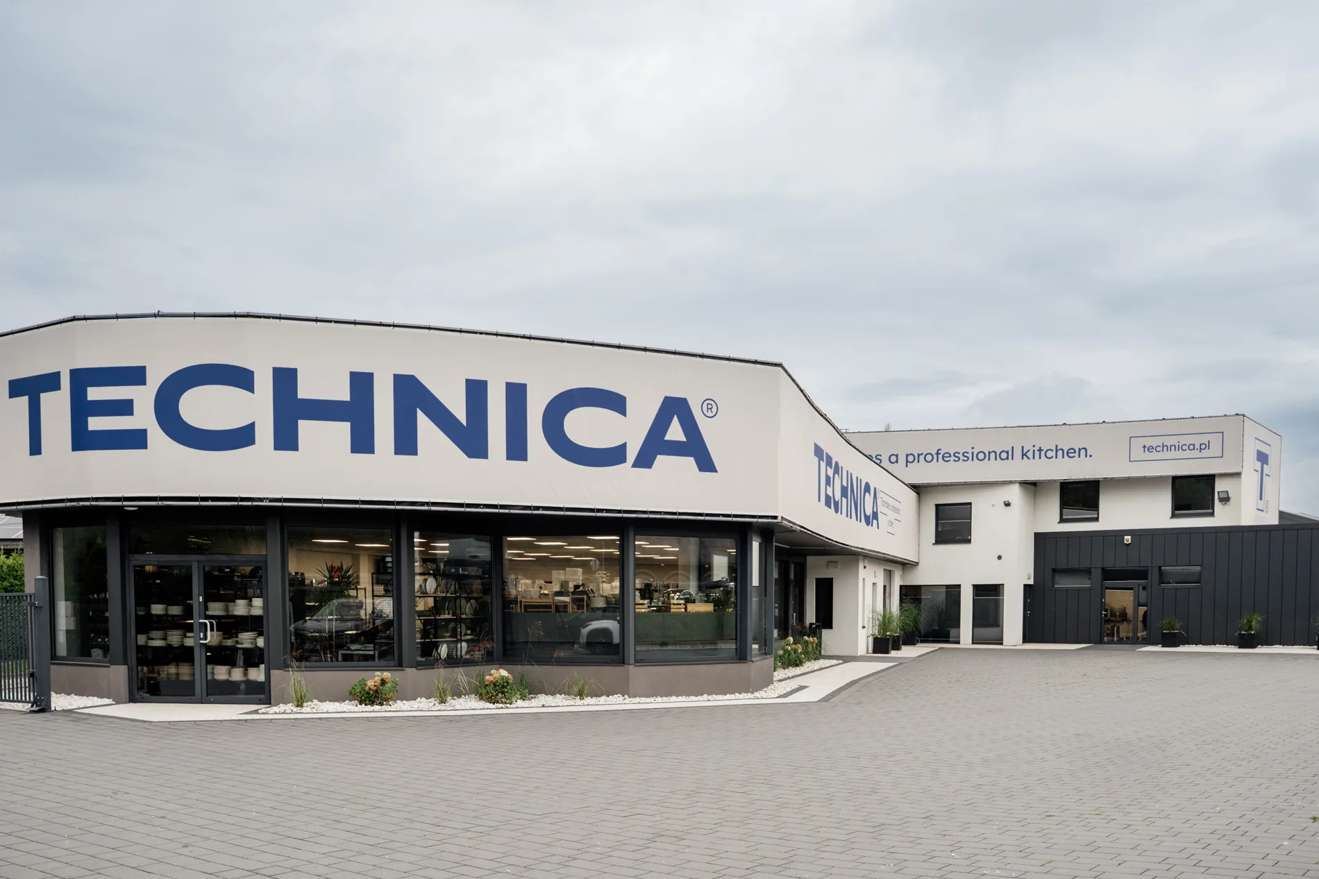 Budynek siedziby Technica z dużym logo na elewacji, nowoczesny showroom i zaplecze biurowo-magazynowe firmy wyposażenia gastronomii.