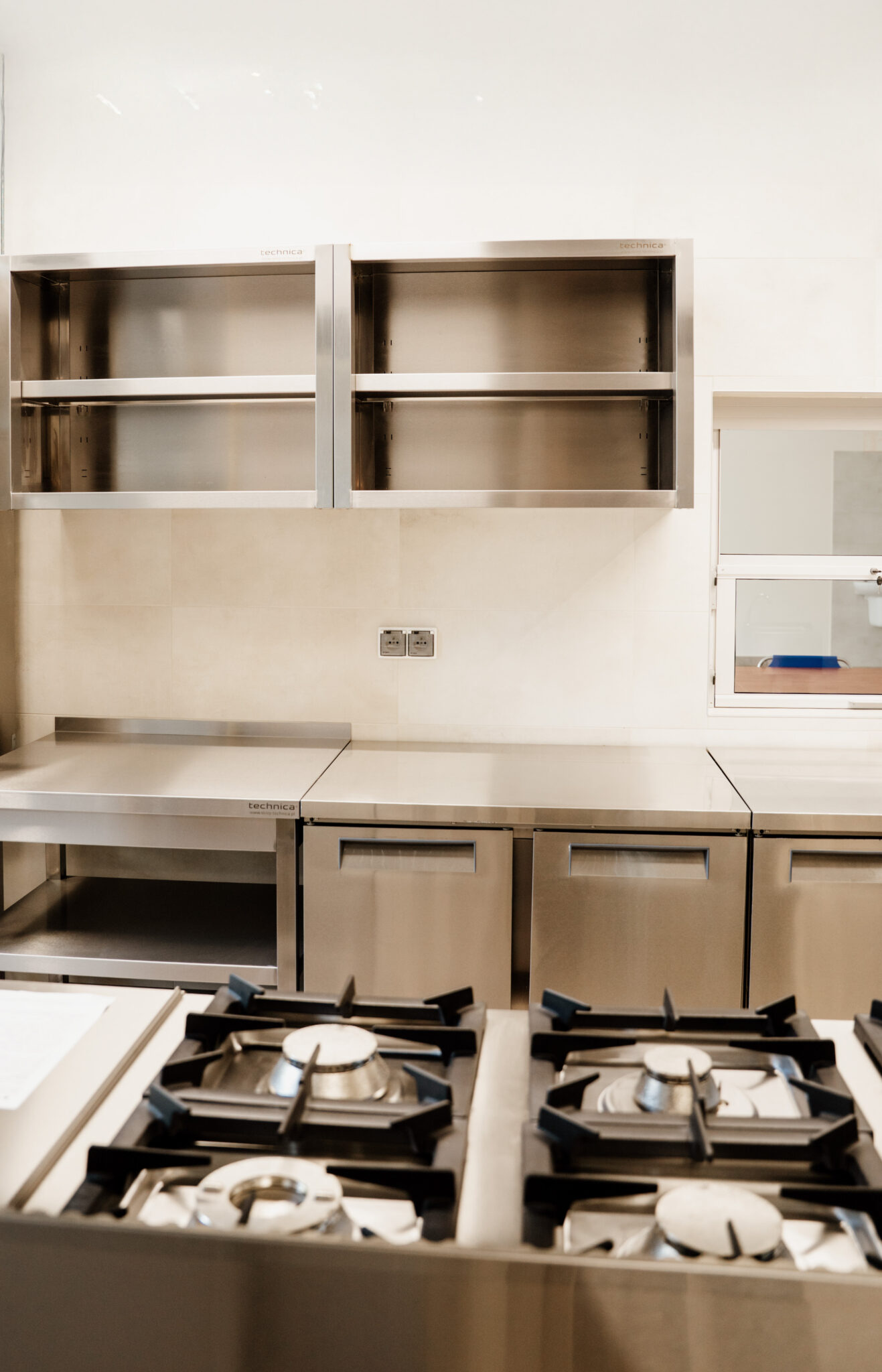 Zabudowa profesjonalnej kuchni gastronomicznej – kuchenka gazowa, stoły robocze i szafki ze stali nierdzewnej Technica.