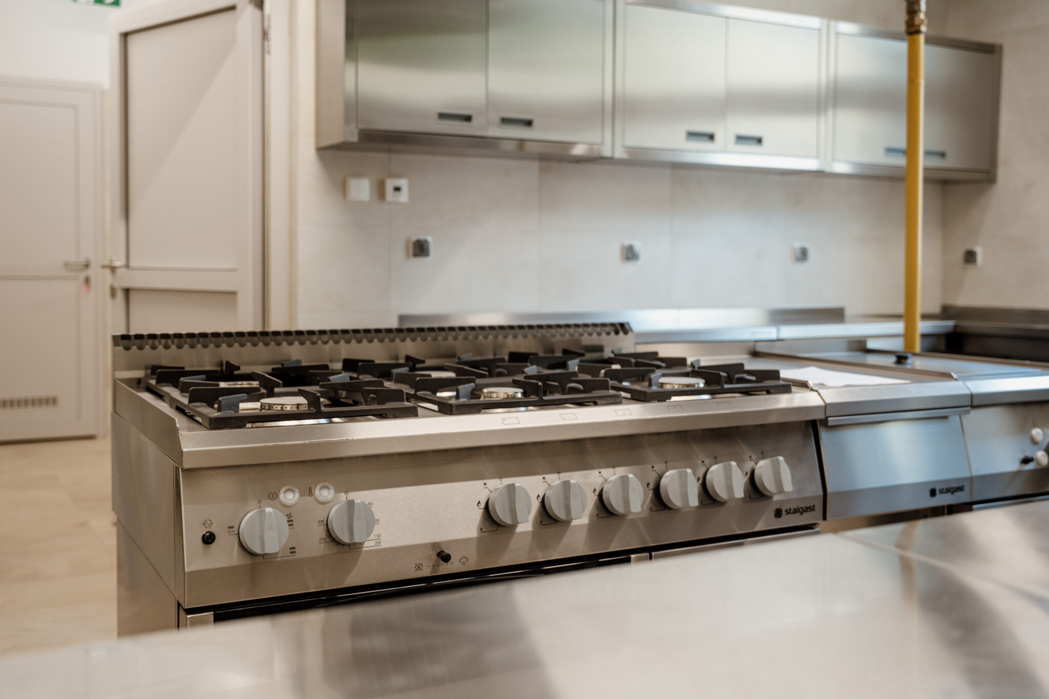Profesjonalna kuchnia gastronomiczna z kuchenką gazową ze stali nierdzewnej – wyposażenie do intensywnej pracy w restauracji.