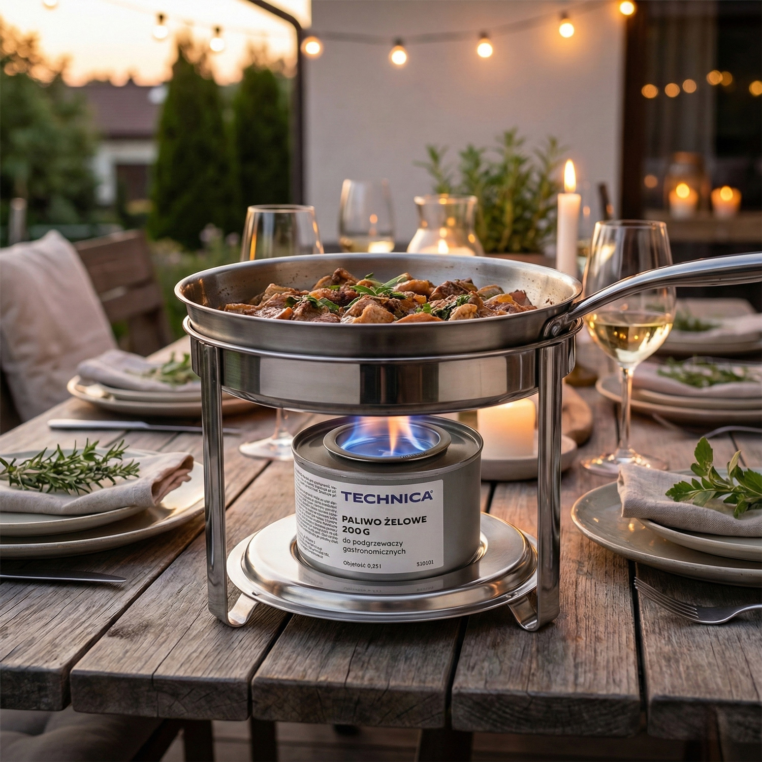 Podgrzewacz gastronomiczny z paliwem żelowym Technica – patelnia z gorącym daniem serwowana na stole podczas kolacji plenerowej.